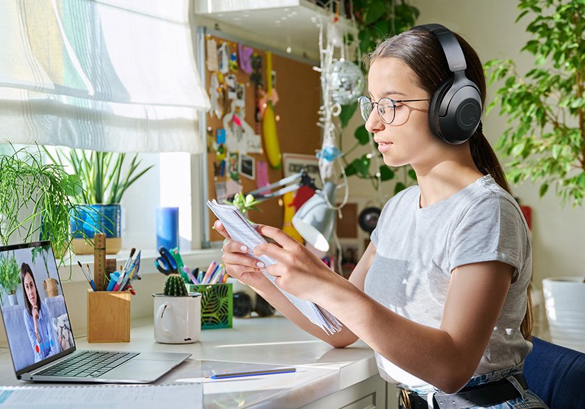 Trabalho Home Profissional trabalhando em home office com laptop e fones de ouvido, representando a liberdade e flexibilidade do trabalho digital durante a Copa do Mundo 2026.